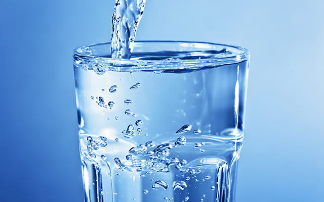 Ein Wasserglas wird mit Wasser befüllt