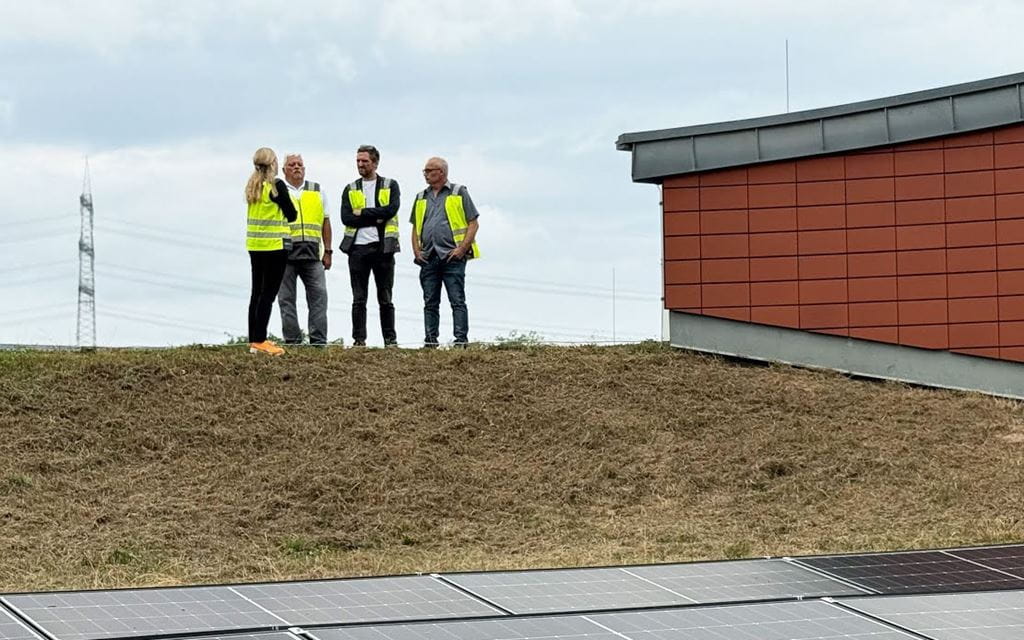 Vier Menschen auf vor der PV-Anlage