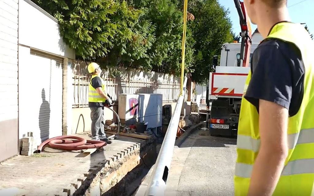 Zwei Männer arbeiten mit einem Kran