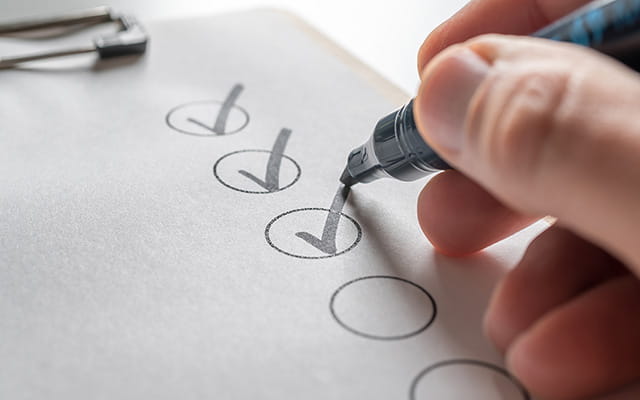 Person hakt eine Checkliste ab Person hakt eine Checkliste ab