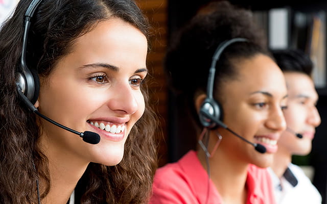 Personen arbeiten mit Headset im Kundenservice Personen arbeiten mit Headset im Kundenservice